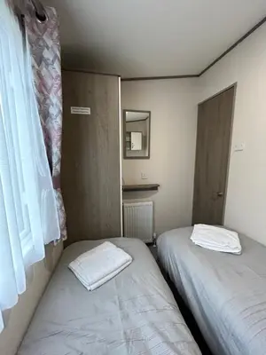 two beds in a small room with a window at Delightful 2 bedroom Caravan, Pencnwc, New Quay in Cross Inn