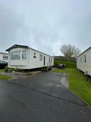 two mobile homes are parked in a parking lot at Delightful 2 bedroom Caravan, Pencnwc, New Quay in Cross Inn