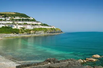 a beach with houses on a hill next to the ocean at 3 Bed in Aberaeron oc-bow330 in Ciliau-Aeron