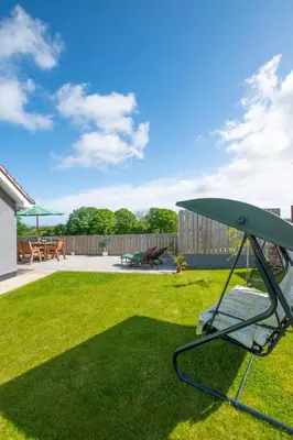 a swing in the grass in a yard at 3 Bed in Aberaeron oc-bow330 in Ciliau-Aeron