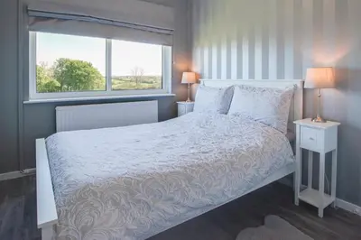 a bedroom with a white bed and a window at 3 Bed in Aberaeron oc-bow330 in Ciliau-Aeron