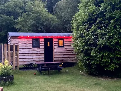 a pink house with a red roof in a yard at Empress En Suite Wagon in Arthog