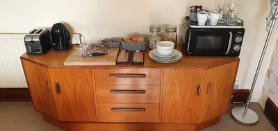 a microwave sitting on top of a wooden cabinet at Large Mach Apartment at Pen Y Coed Hall in Dolgellau
