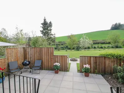 a garden with a fence and a patio at No1 The Lodge in Bishops Castle