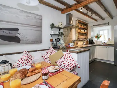 a kitchen with a table with a plate of food at Bryniau Bychain Cottage in Machynlleth