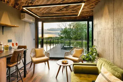 a kitchen and living room with a view of a deck at Rusty Boathouse in Llanarth