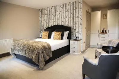 a bedroom with a large bed and a chair at The Charlton Arms in Ludlow
