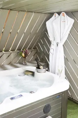 a bath tub with a white robe hanging on a wall at The Charlton Arms in Ludlow