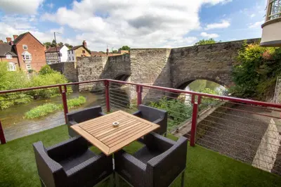 a table and chairs on a balcony with a bridge at The Charlton Arms in Ludlow