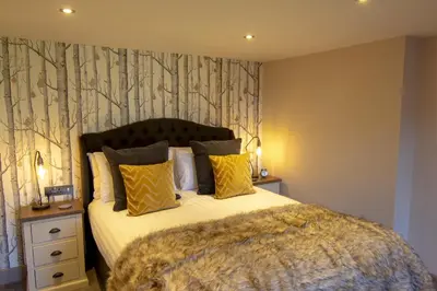 a bedroom with a large bed with yellow pillows at The Charlton Arms in Ludlow
