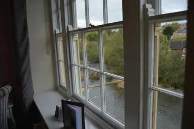 a window with a view of a dog looking out at The Charlton Arms in Ludlow
