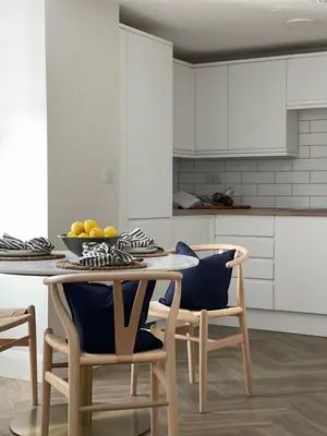 a kitchen with a table and chairs with a bowl of fruit at Richardson Apartment in Aberaeron
