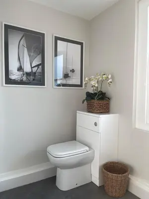 a bathroom with a toilet and two pictures on the wall at Richardson Apartment in Aberaeron