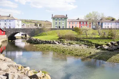 a bridge over a river with buildings in the background at Richardson Apartment in Aberaeron