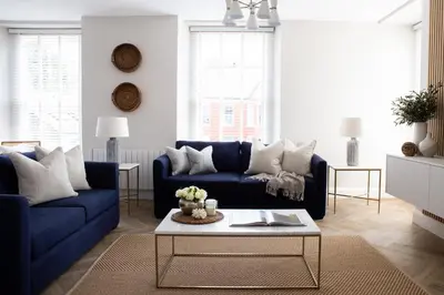 a living room with blue couches and a coffee table at Salthouse apartment in Aberaeron