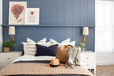 a bedroom with blue walls and a bed with a hat on it at Morahan apartment in Aberaeron