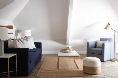 a living room with a blue couch and two chairs at Morahan apartment in Aberaeron