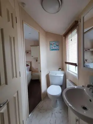 a bathroom with a toilet and a sink at Sea and Mountain view Sunbeach Holiday Snowdonia in Llwyngwril