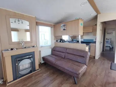 a living room with a couch and a fireplace at Sea and Mountain view Sunbeach Holiday Snowdonia in Llwyngwril
