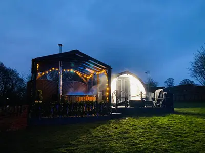 a small greenhouse with lights in a field at night at Cherry Pod in Shrewsbury