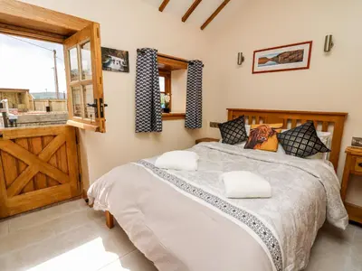 a bedroom with a large bed and a window at The Old Cobblers Shop in Llandrindod Wells