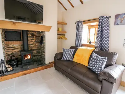 a living room with a couch and a fireplace at The Old Cobblers Shop in Llandrindod Wells