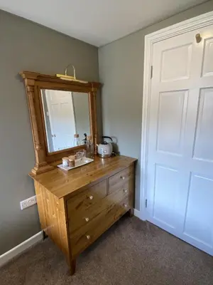 a bathroom with a wooden dresser with a mirror at Tom's of Tregaron in Tregaron