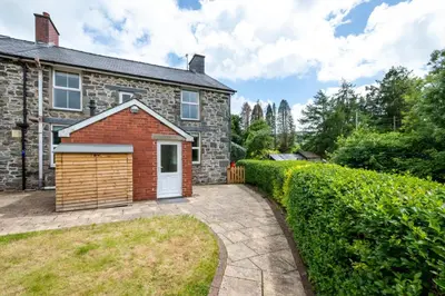 a brick house with a garage in the yard at 4 Bed in Machynlleth oc-wad350 in Cemmaes