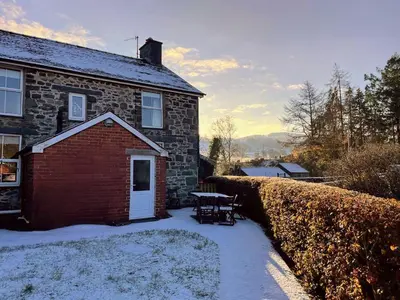 a brick house with a picnic table in the snow at 4 Bed in Machynlleth oc-wad350 in Cemmaes