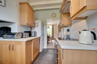 a kitchen with wooden cabinets and white counter tops at 4 Bed in Machynlleth oc-wad350 in Cemmaes