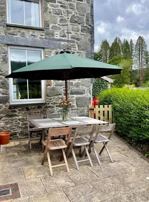 a table and chairs with an umbrella on a patio at 4 Bed in Machynlleth oc-wad350 in Cemmaes