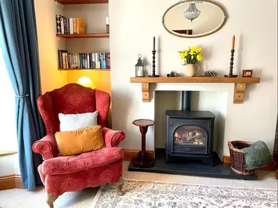 a living room with a red chair and a fireplace at 4 Bed in Machynlleth oc-wad350 in Cemmaes