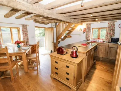 a kitchen with a table and a dining room at Manor Cottage in Church Stretton