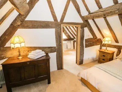 a bedroom with a bed and a desk with two lamps at Manor Cottage in Church Stretton