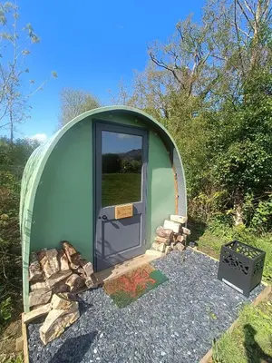 a green dome house with a door in the middle at MotoCamp Wales -Camping Pods in Dolgellau