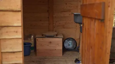 an inside view of a wooden room with a clock at MotoCamp Wales -Camping Pods in Dolgellau