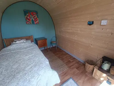 a bedroom with a bed in a wooden room at MotoCamp Wales -Camping Pods in Dolgellau