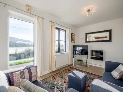 a living room with a couch and a tv at Beacons Cottage-Uk36406 in Bronllys