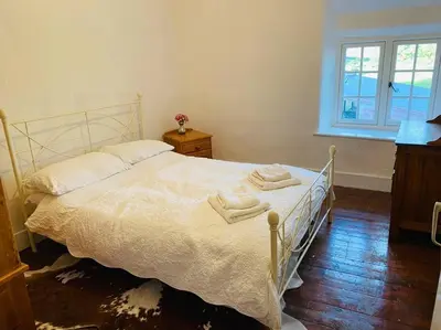 a bedroom with a white bed with towels on it at Farmhouse Cottage set in beautiful countryside in Oswestry