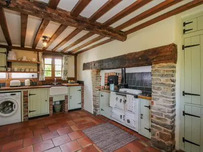 a kitchen with white appliances and a brick wall at 46-47 Lydbury North in North Lydbury