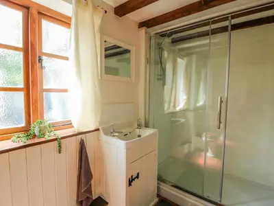 a bathroom with a glass shower and a sink at 46-47 Lydbury North in North Lydbury