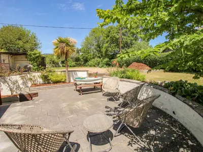 a patio with chairs and a table in a yard at 46-47 Lydbury North in North Lydbury