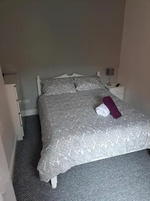 a bedroom with a bed with a purple towel on it at Entire town house with free parking in Oswestry