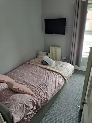 a bedroom with a bed and a flat screen tv at Entire town house with free parking in Oswestry