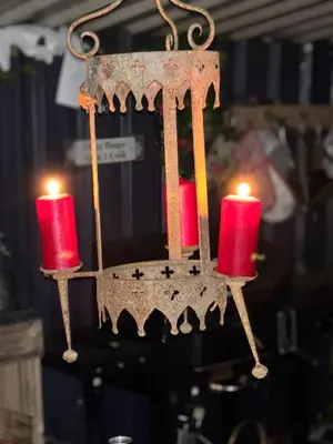a chandelier with two red candles on it at Four seasons with wood fuel hot tub Country retreat in Hereford