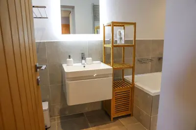 a bathroom with a sink and a mirror and a tub at Apartment Seven in Shrewsbury