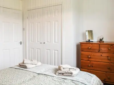 a bedroom with a bed with towels on it at Llwyn in Bettws Gwerfil Goch