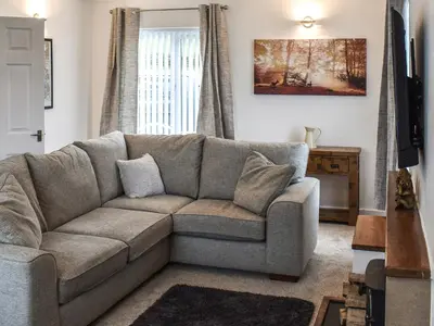 a living room with a couch and a window at Llwyn in Bettws Gwerfil Goch