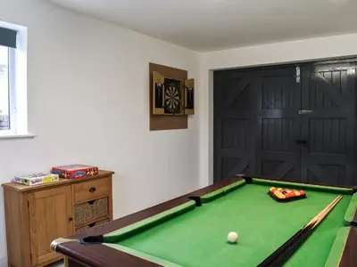 a room with a pool table and a door at Llwyn in Bettws Gwerfil Goch