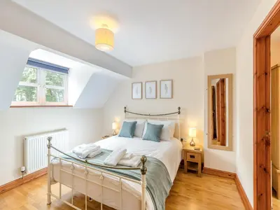 a bedroom with a large white bed with blue pillows at Cysgod Y Capel in Cerrigydrudion